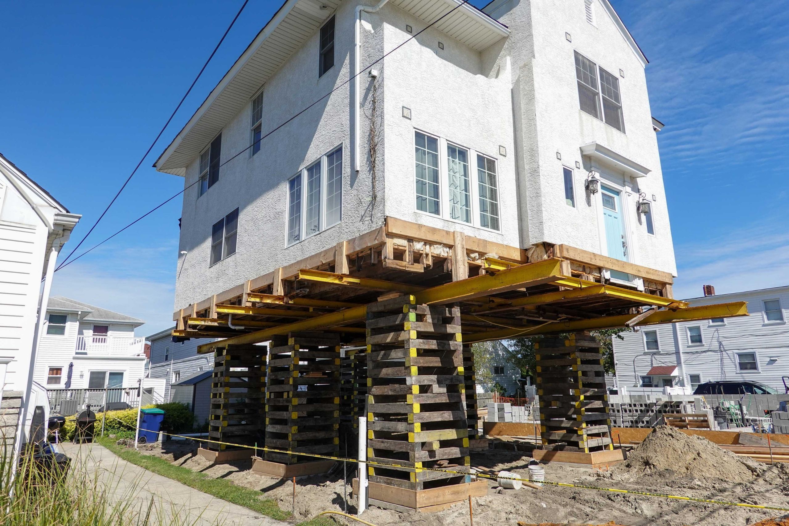 A team of professionals using specialized equipment to raise a house in Florida, preparing it for elevation and renovation